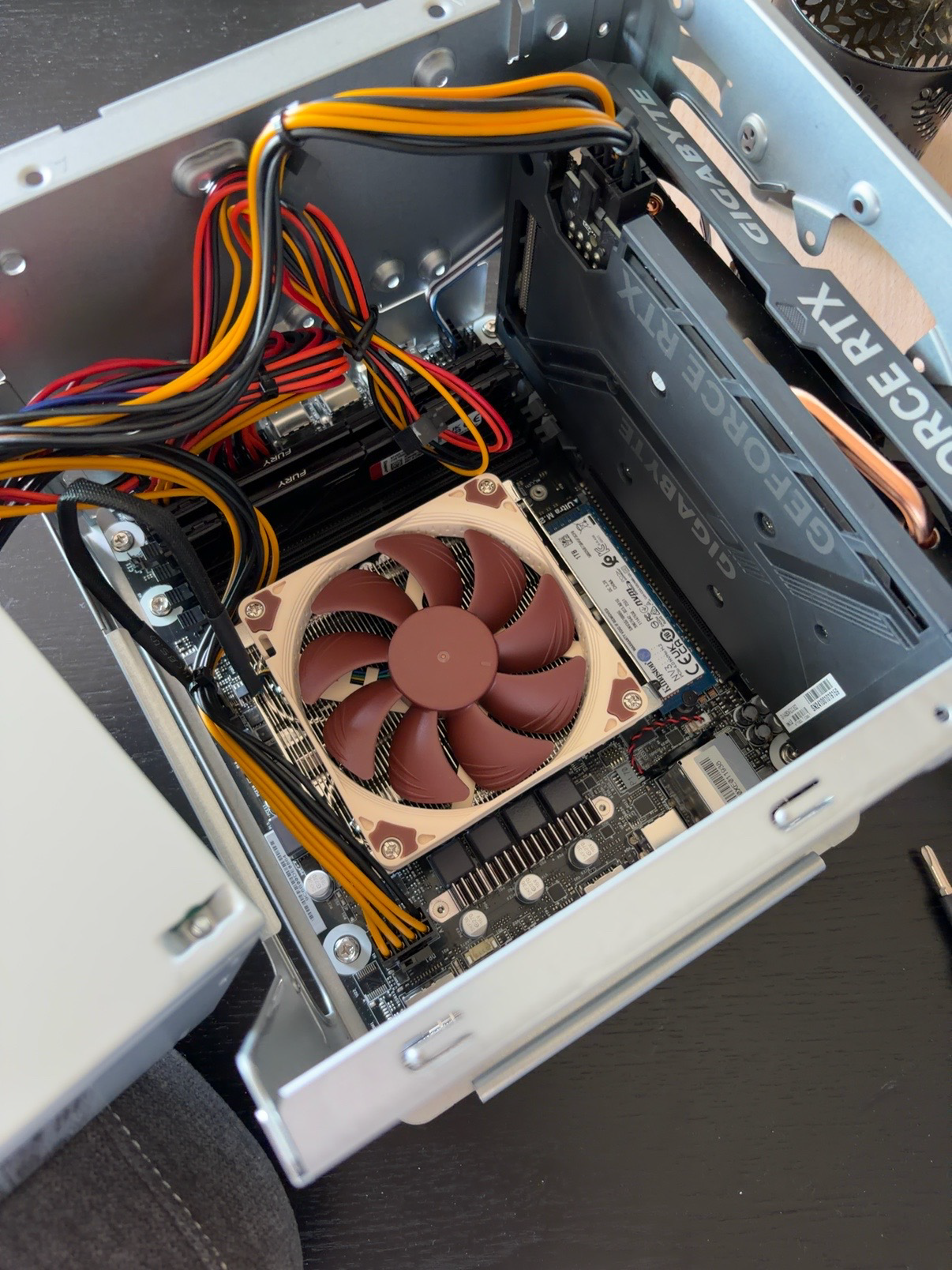 Inside TARS during assembly, showing the compact case, CPU cooler, NVMe SSD, and GeForce RTX graphics card
