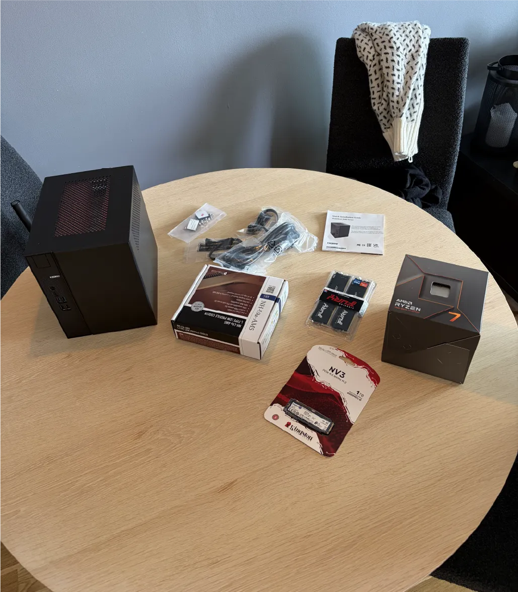 Components for Atlas laid out before assembly, including the compact case, Ryzen processor, memory, NVMe SSD, and CPU cooler